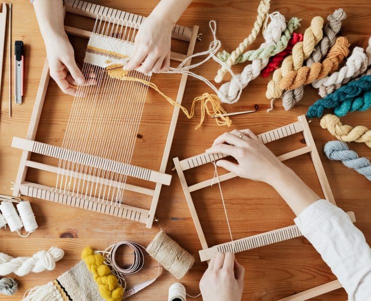 top view photo of two person s hands weaving